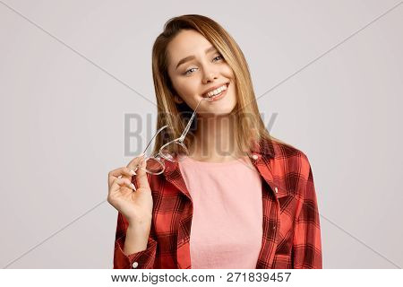 Beautiful Girl Standing In An Isolated Background. Studio Shot Of Attractive Student Has Gleeful Exp