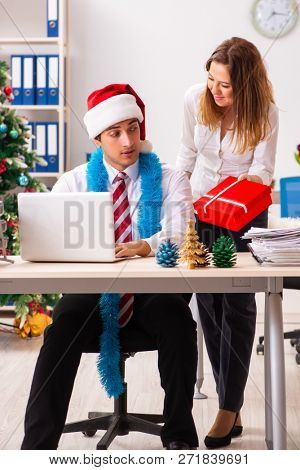 Colleagues exchaing christmas presents in office