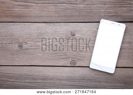 Mobile Phone With Blank Screen On Grey Wooden Table. Smartfone White