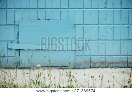 Blue Hatchway In Wall Of Building Close Up With Copy Space. Background Of Cyan Closed Hatch On Tiles