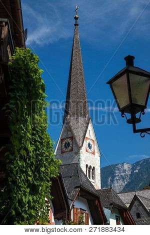 A Church Tower In The Idyllic Village Of Hallstatt, Austria