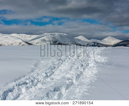 Sledge Trace And Footprints On Winter Mountain Hill Top And Snow Covered Picturesque Alp Chornohora 