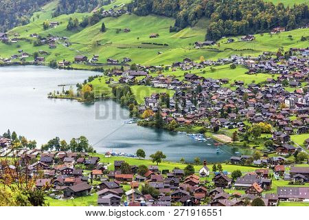 Amazing Dream Like Swiss Alpine Mountain Landscape, Wooden Chalets On Green Fields In Lungern Of Swi
