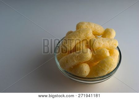 Corn Puffs In A Glass Bowl. Crunchy Flavored Puffed Snacks. Party, Movie Snacks.