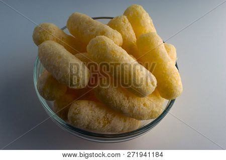 Corn Puffs In A Glass Bowl. Crunchy Flavored Puffed Snacks. Party, Movie Snacks.
