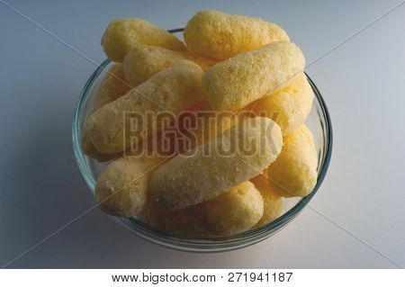 Corn Puffs In A Glass Bowl. Crunchy Flavored Puffed Snacks. Party, Movie Snacks.