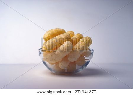 Corn Puffs In A Glass Bowl. Crunchy Flavored Puffed Snacks. Party, Movie Snacks.