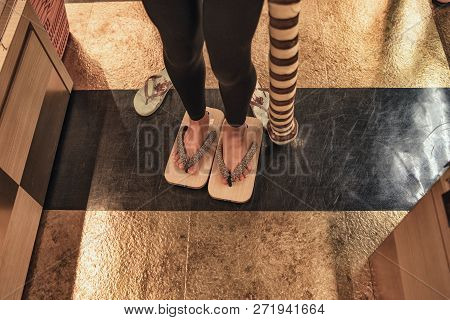 A Girl Tries On Japanese Wooden Shoes.japanese Clog, Traditional Japanese Sandals Shoes. Japanese Sh