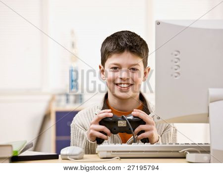 Jongen die video game controller met plezier spelen video spel op computer