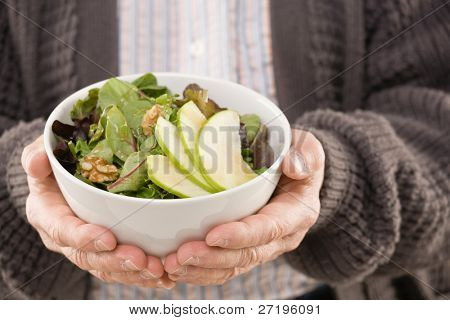 คนที่ถือสลัดผลไม้สด สุทธ์