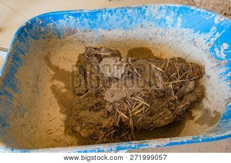 Clay, Dirt With Straw In Barrow Wheel. Cob, Clom Eco Building Construction Techniques