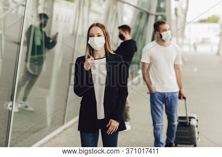 Figures Of Young People In Protective Masks Near The Airport. Safe Travel During A Pandemic. Airplan