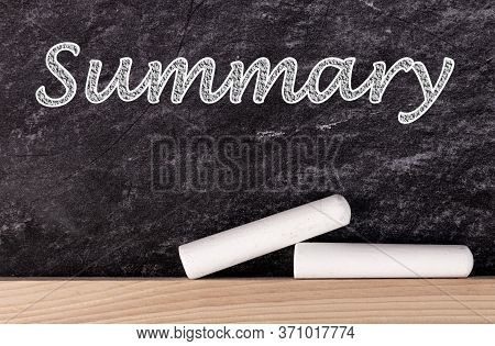 Summary Text On Blackboard With Two Pieces Of Chalk.