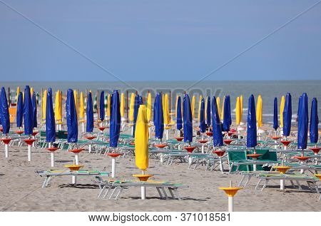 Closed Umbrellas On The Beach Without People Due To The Economic Crisis That Hit The Tourism Sector 