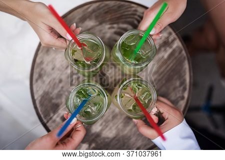 Four Cool Drinks On The Table. View From The Vertu. People Keep The Glasses