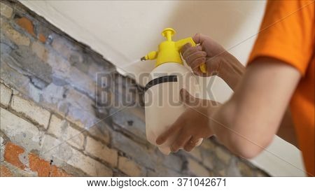 A Worker Is Applying A Primer To A Brick Wall. Applying A Primer Using A Sicator. Applying A Primer 