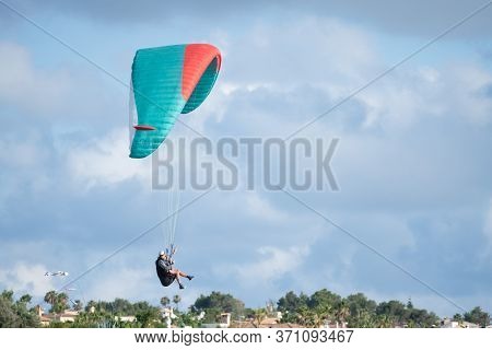 Llucmajor, Majorca, Balearic Islands, Spain - June 10, 2020: Man Paragliding Landing With Cloudy Blu
