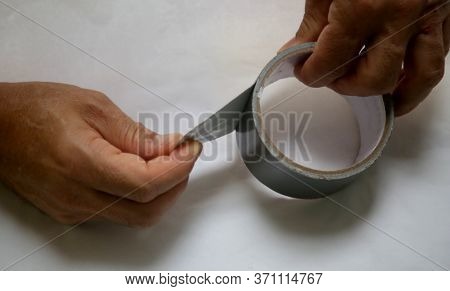 Salvador, Bahia / Brazil - May 24, 2020: Hand Opening Adhesive Tape On A Roll.