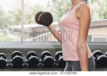 Sport Woman Lifting Dumbbells Weights Focused Exercise On Her Bicep For Compact Arm Size.