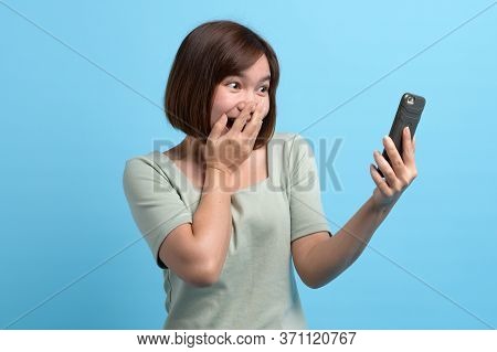 Shock / Surprise And Wow Concept. Asian Woman Looking In Mobile Phone And Being Surprised Or Astonis