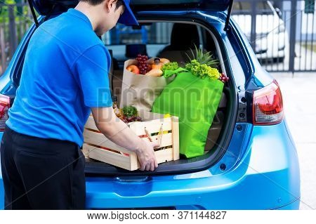 Asian Delivery Man In Green T-shirt Delivering Food, Fruit, Joice And Vegetable To Home - Online Gro