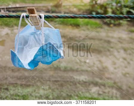 Disposable Surgical Face Mask Drip-dry In Outdoor Background. Stock Photo.