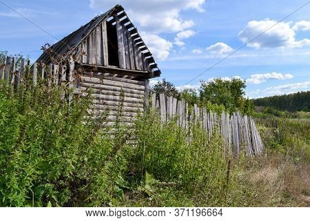an old barn and fence on the outskirts of the village