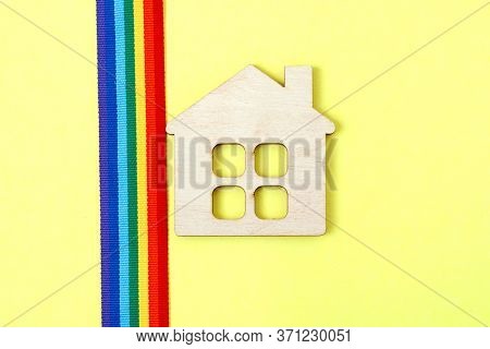 Mini Toy Wooden House And Lgbt Rainbow Ribbbon On Yellow Background