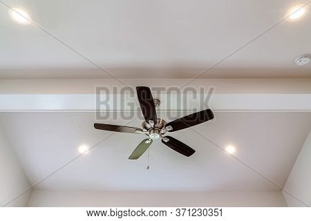 Ceiling Fan With Wood Blades And Built In Lights On The Ceiling Beam Of Home