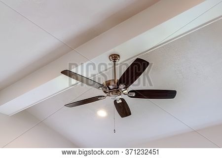 Decorative Wood Beam With Standard Ceiling Fan And Lights Inside A House