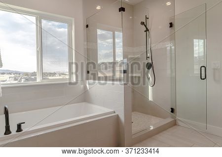 Built In Bathtub With Black Faucet And Shower Stall With Half Glass Enclosure