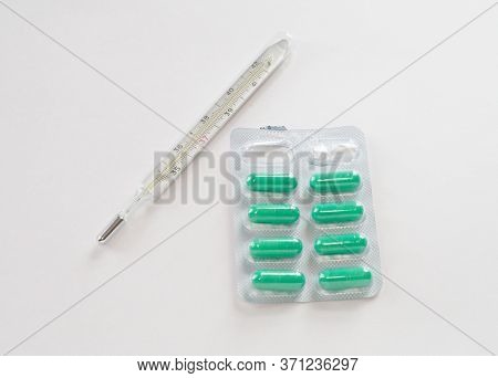 Mercury Thermometer And Green Pills In Cover