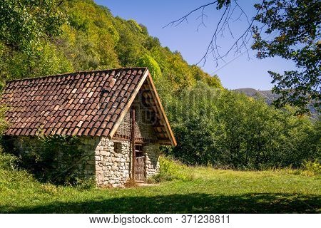 Old Stone House With Tiled Roof In Georgian Mountain Forest
