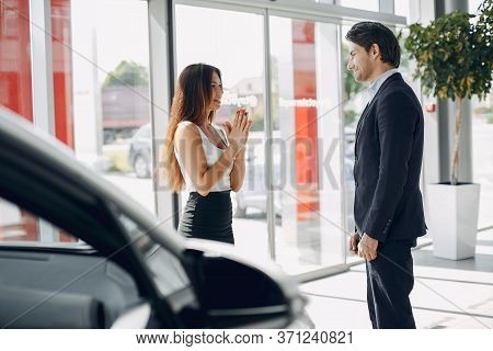 Stylish And Elegant Couple In A Car Salon