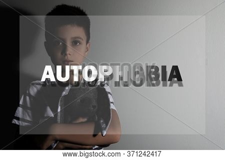 Sad Little Boy With Toy Near Light Wall. Autophobia