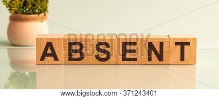 Absent Word Made With Building Blocks Isolated On White. Potted Flower In The Background On The Left