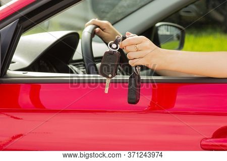 A Girl In A Red Car Demonstrates The Keys To A New Car, The Concept Of Buying A Vehicle