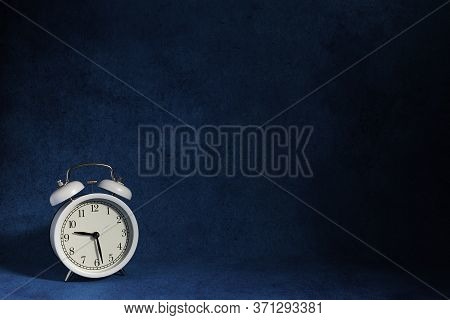 White Vintage Alarm Clock And Wooden Mannequin Supported On Wood Table And Wood Background