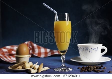 Glass Of Orange Juice And Steaming Cup Of Coffee