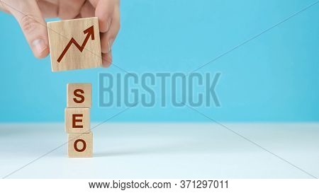 Man Puts Wooden Blocks With The Word Seo Search Engine Optimization.