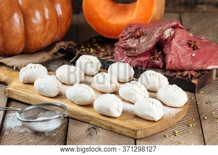 Traditional Russian Dish Of Manti Dumplings With Meat And Pumpkin. On A Wooden Country Background. H