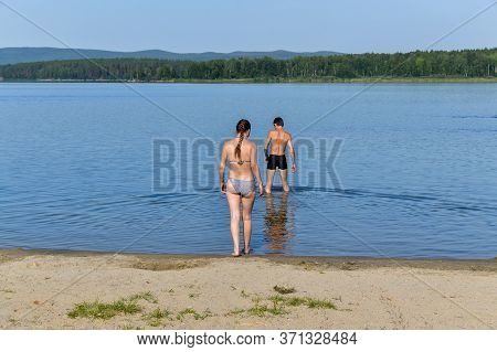a girl and a boy go swimming in the lake