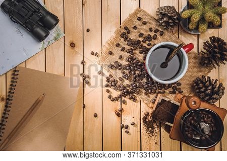 Cup Black Coffee And Coffee Beans, Coffee Grinder, Map, Binoculars On The Table Wooden
