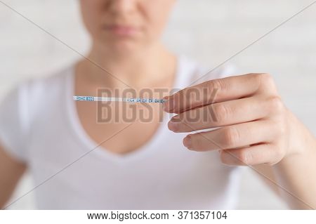 Sad Woman Shows A Negative Ovulation Test. The Concept Of Female Infertility And Low Luteinizing Hor