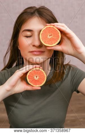Girl With Closed Eyes And Fruit On A Light Background. In The Hands Of A Beautiful Young Woman Of Ha