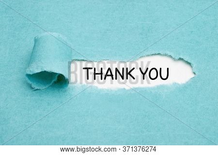 Handwritten Text Thank You Appearing Behind Ripped Blue Paper. Appreciation, Gratefulness, Or Thankf