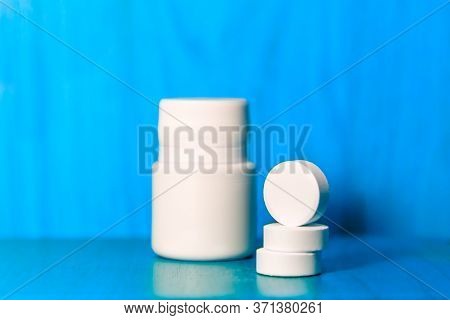 Assorted Pharmaceutical Medicine Pills And Bottle On Blue Background. Copy Space For Text