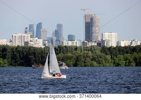 View To The Moscow City In Summer From The Stroginsky Backwater. Sailboat On Background Of Park And 
