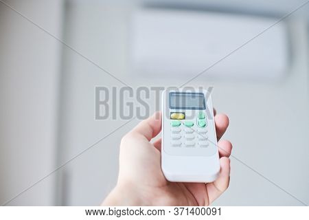 Air Condition Remote Control. Hand With Room Conditioner Remote Control. Air Temperature Switch For 