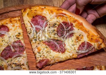Hand Holding Pepperoni Pizza In Brazil Is Called Pizza De Calabresa. Close Up.